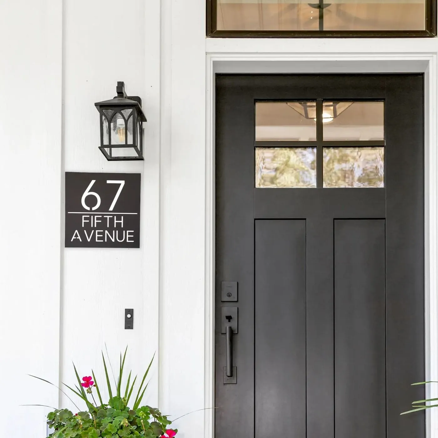 New construction home with custom black address numbers installed by the front entry